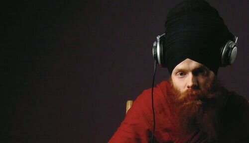 DJ Redlox in headphones and a red shawl
